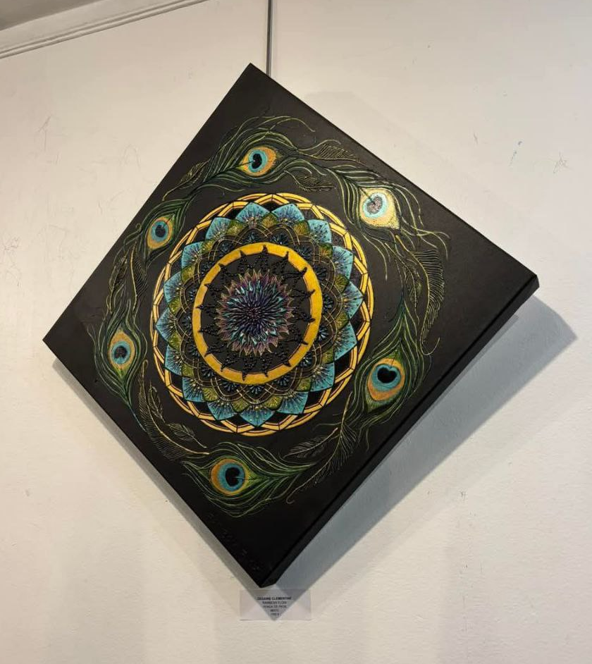 Oeuvre en relief de la peintre Clémentine Degaine [ Rainbow Flow, nommé Ronde de Paon, illustrant un mandala avec de la géométrie sacrée et des plumes de paon, le volume de sa technique est bien visible. Les tons sont noirs, dorés et turquoise-verts. On peut y voir des contrastes entre mat et brillant également et des jeux de lumière